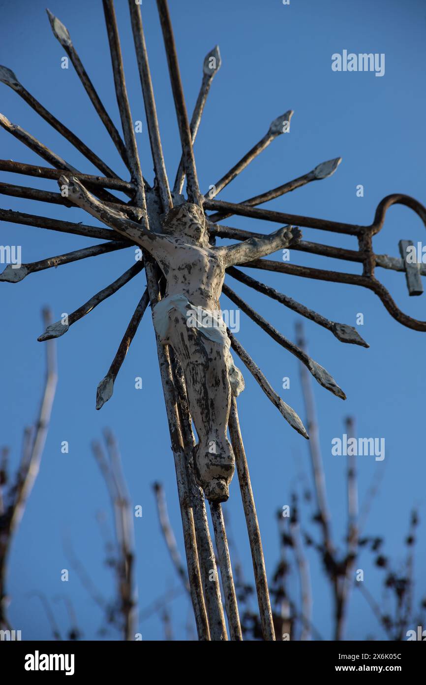 Vecchia croce di metallo con un crocifisso su uno sfondo cielo senza nuvole. Immagine verticale. Foto Stock