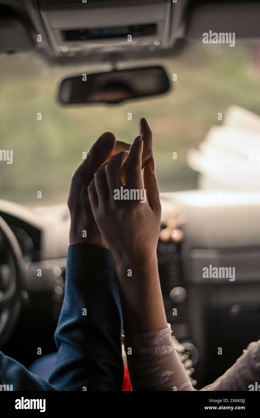 una donna con un uomo in macchina. primo piano delle mani Foto Stock