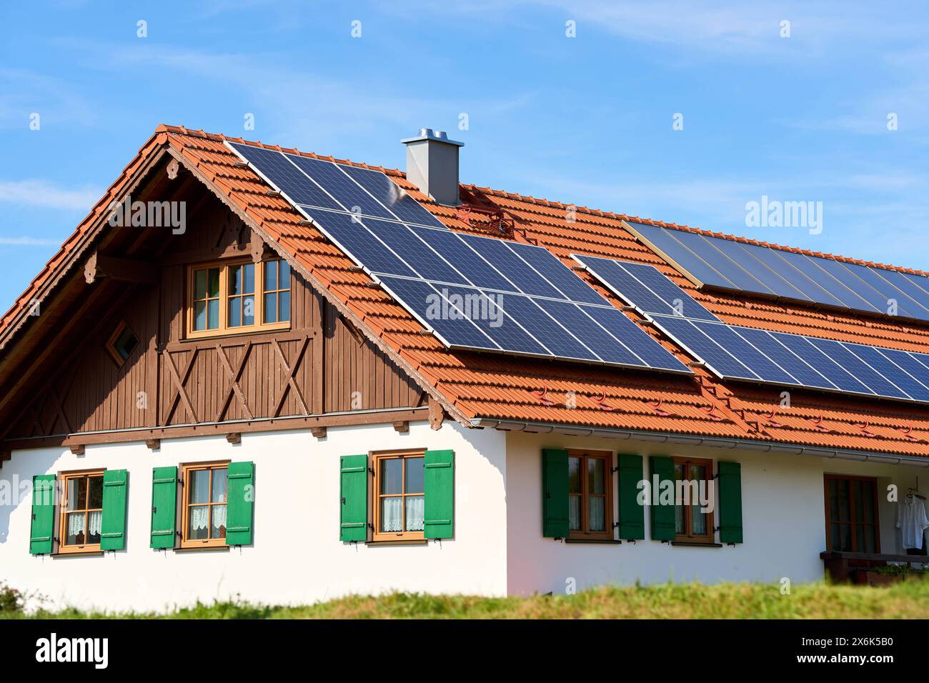 Baviera, Germania - 11 maggio 2024: Agriturismo in Baviera con celle solari sul tetto. Concetto di energia fotovoltaica ed ecologica *** Bauernhaus a Bayern mit Solarzellen auf dem Dach. Photovoltaik und Grüne energie Konzept Foto Stock