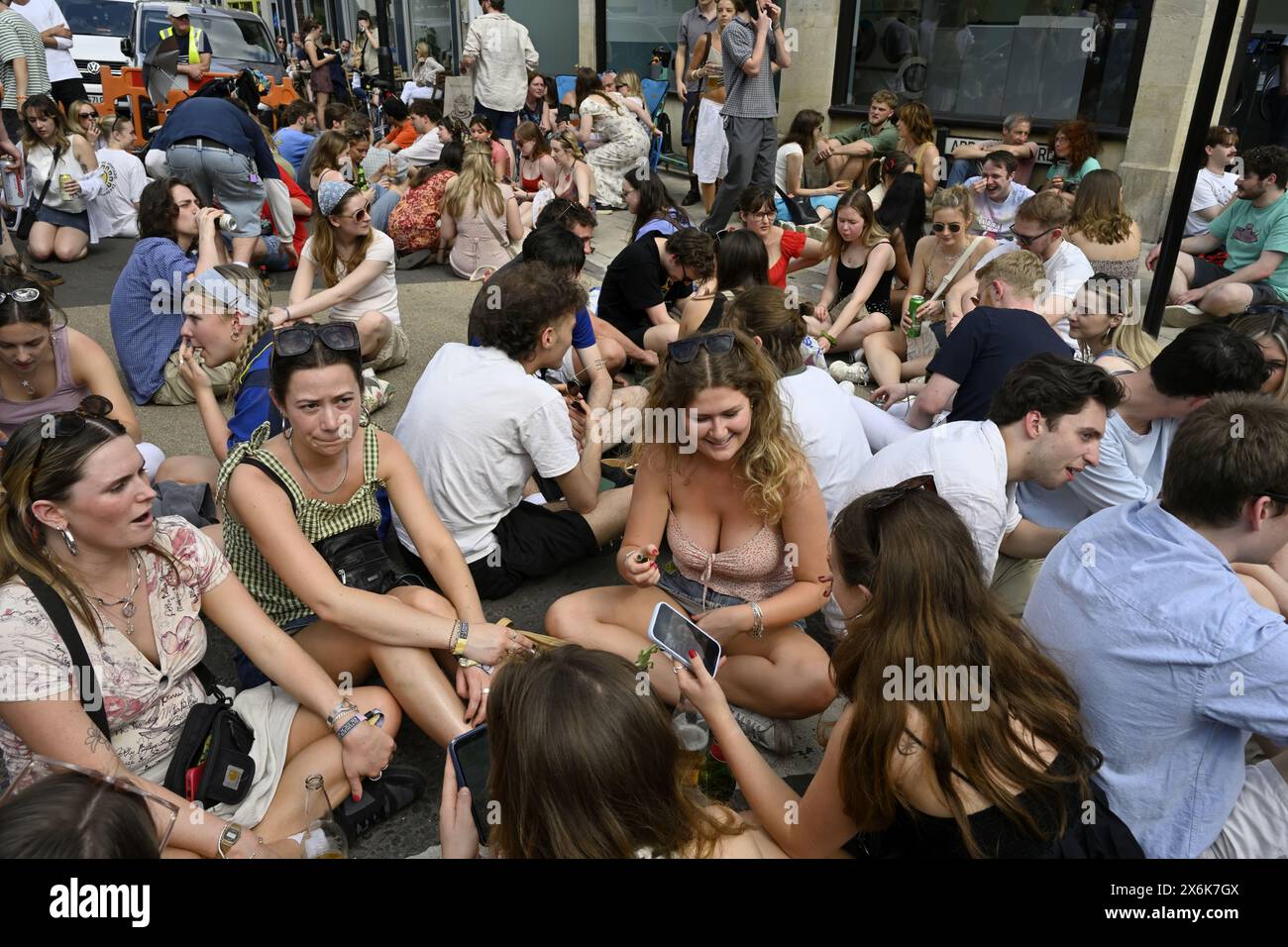 Folla di persone sedute a terra alla festa di strada, Cotham Hill, Bristol Foto Stock