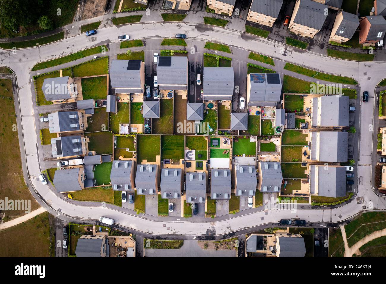 Vista dall'alto verso il basso sopra un blocco di case suburbane di nuova costruzione nel Regno Unito con piccoli giardini Foto Stock