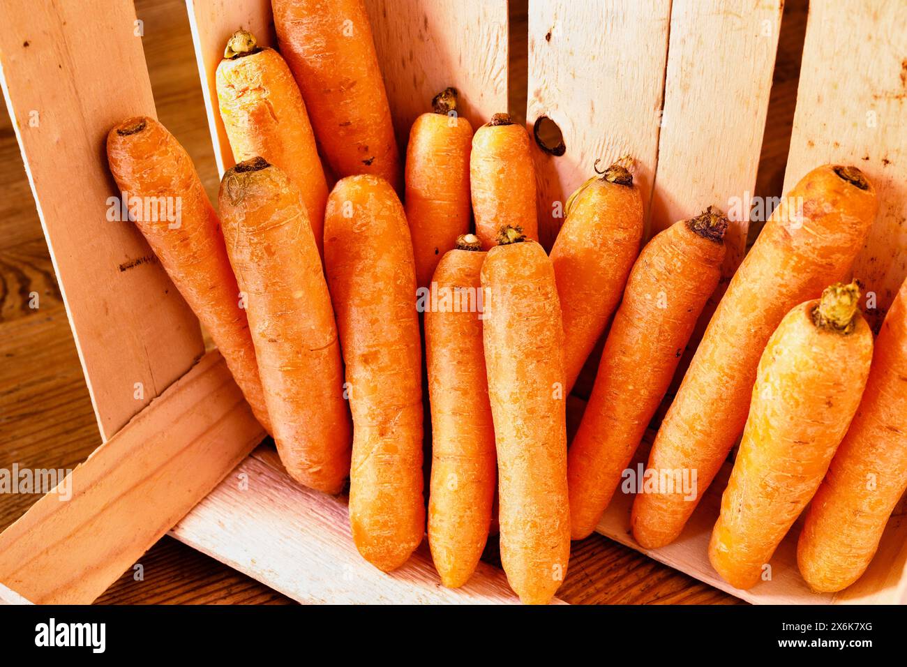 Mazzo di carote arancioni in scatola di legno su tavola di legno, Foto Stock