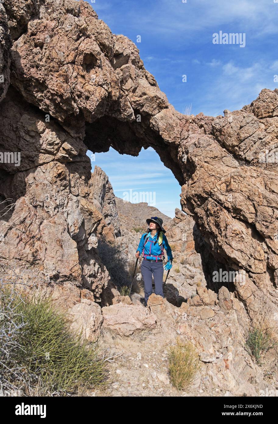 Una donna escursionista guarda l'arco calcareo sulla Old Dad Mountain nel deserto del Mojave in California Foto Stock