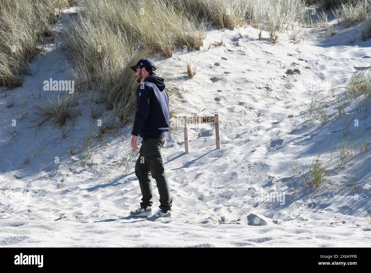 Lista, Germania. 12 maggio 2024. Un uomo cammina di fronte a una barriera di legno con le parole "No Way" nella riserva naturale di Lister Ellenbogen (Sylt). La 26enne Stella Kinne lavora qui come ranger per proteggere gli animali. Crediti: Lea Sarah Albert//dpa/Alamy Live News Foto Stock