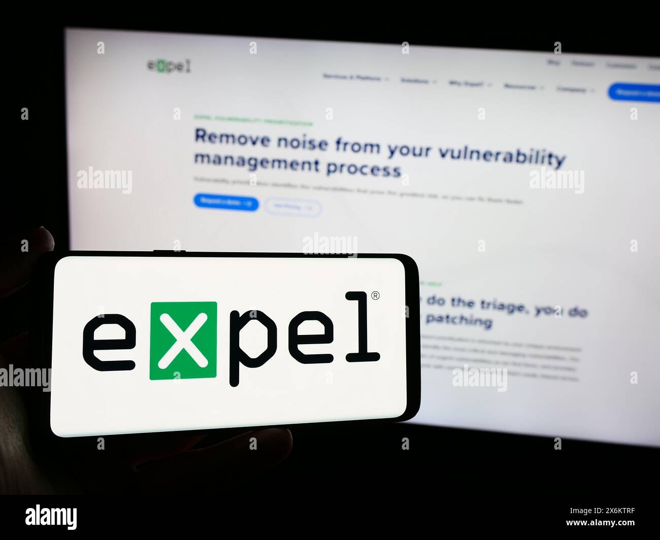 Persona che detiene un telefono cellulare con il logo della società americana di sicurezza informatica Expel Inc. Di fronte alla pagina Web aziendale. Mettere a fuoco il display del telefono. Foto Stock
