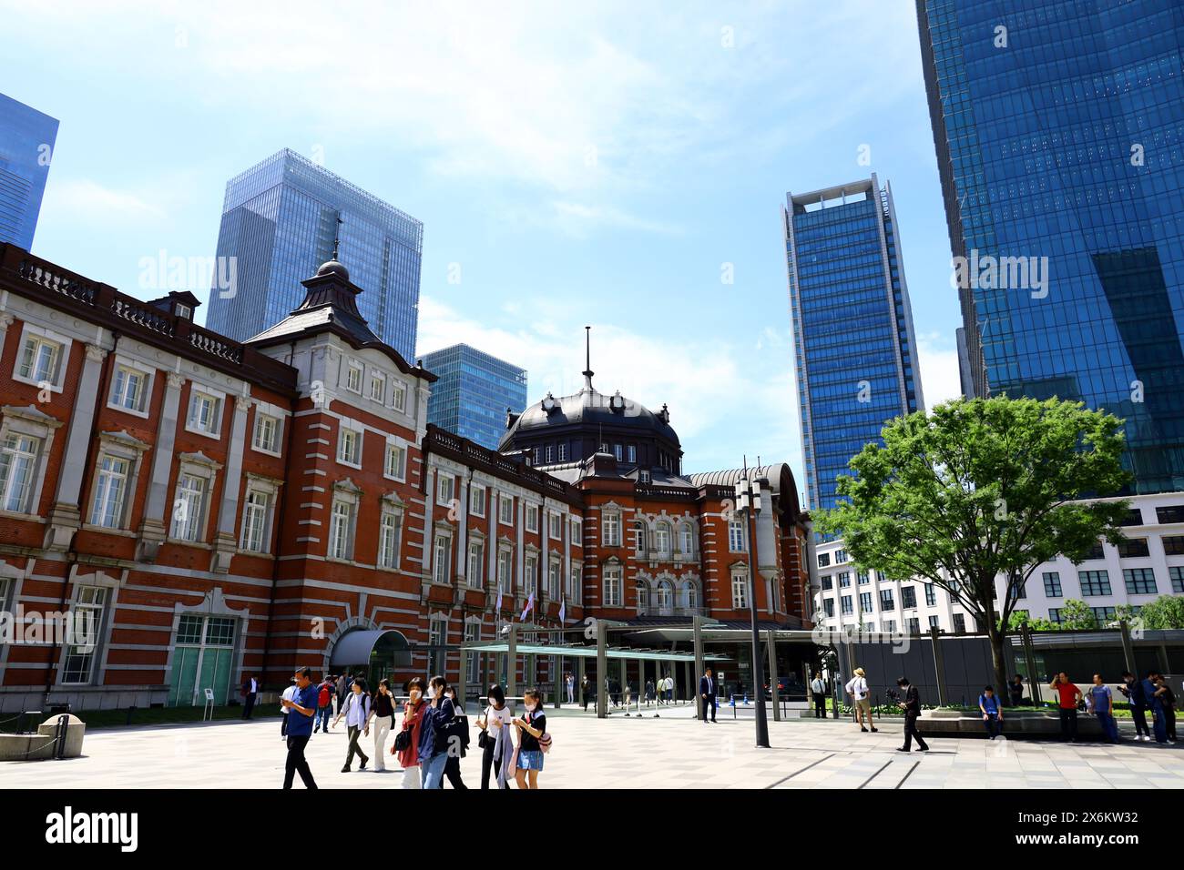 Vita quotidiana in Giappone turisti che visitano la stazione di Tokyo costruita in mattoni e la piazza della stazione Foto Stock