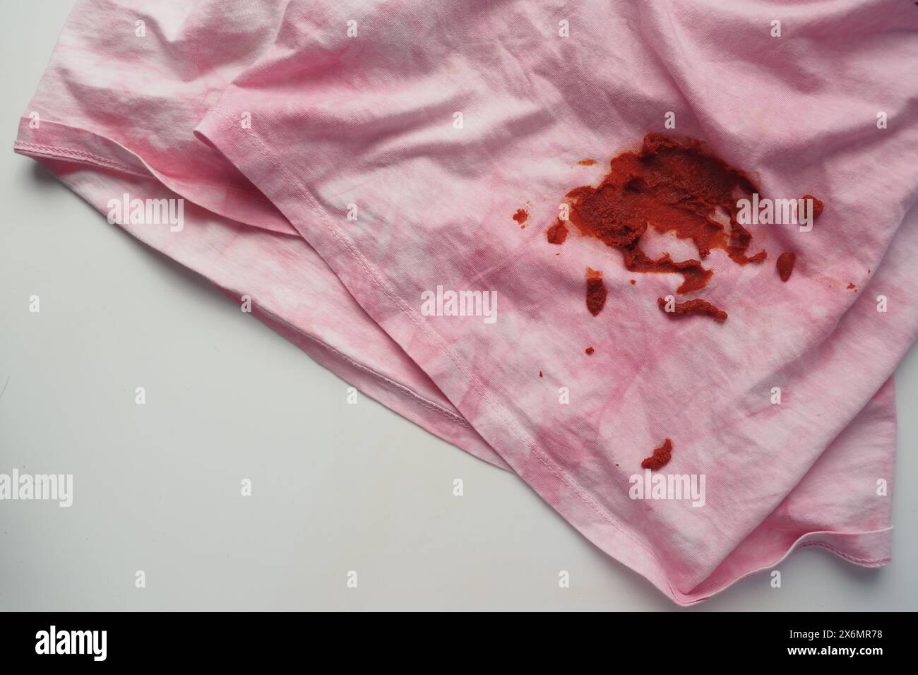 Salsa di pomodoro versata su una camicia di colore grigio. Macchie di cibo sulla camicia Foto Stock