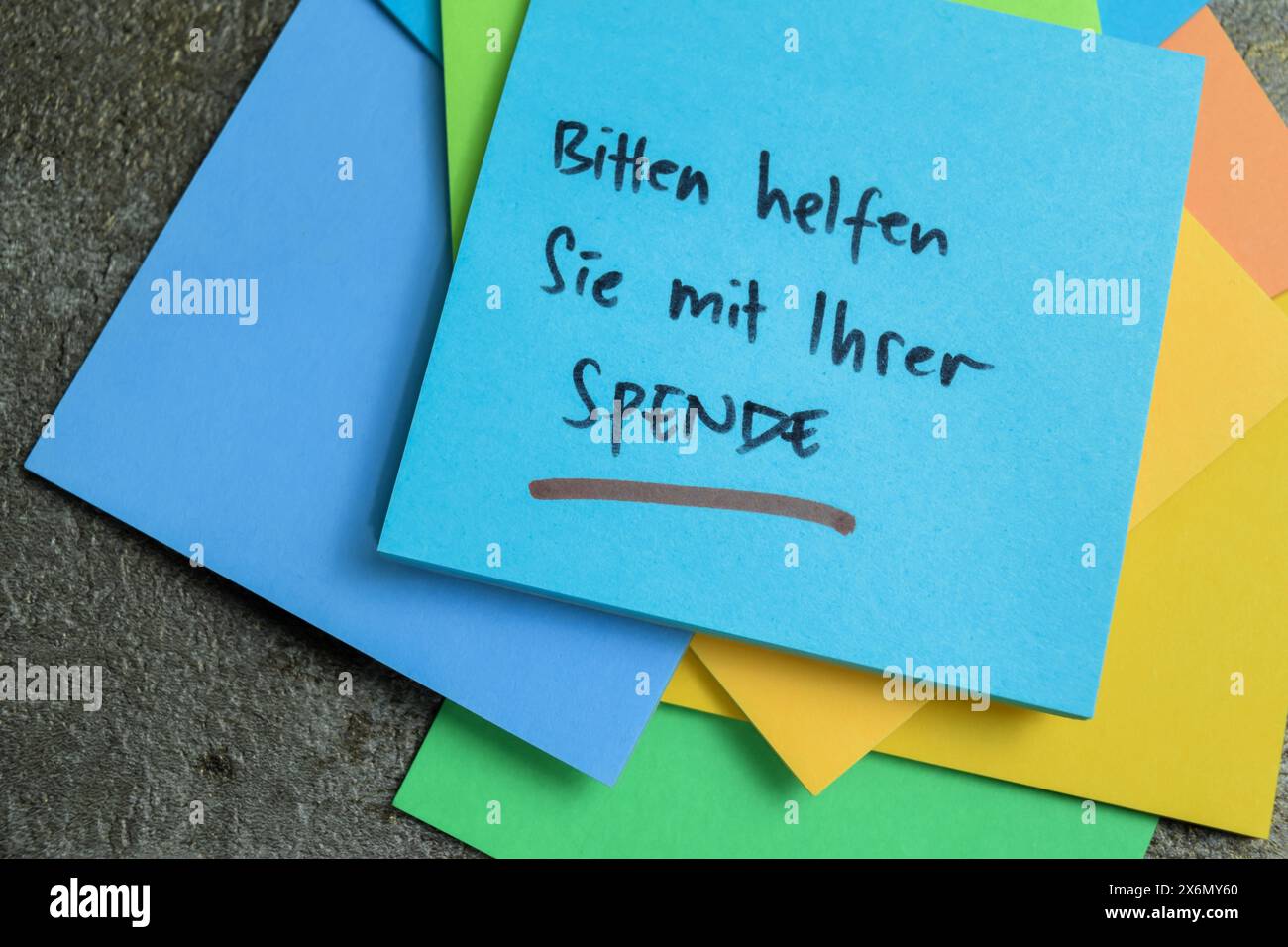 Concetto di apprendimento della lingua - tedesco. Bitten Helfen Sie mit ihrer Spende significa che ti preghiamo di aiutarti con la tua donazione scritta su appunti adesivi. Lingua tedesca Foto Stock