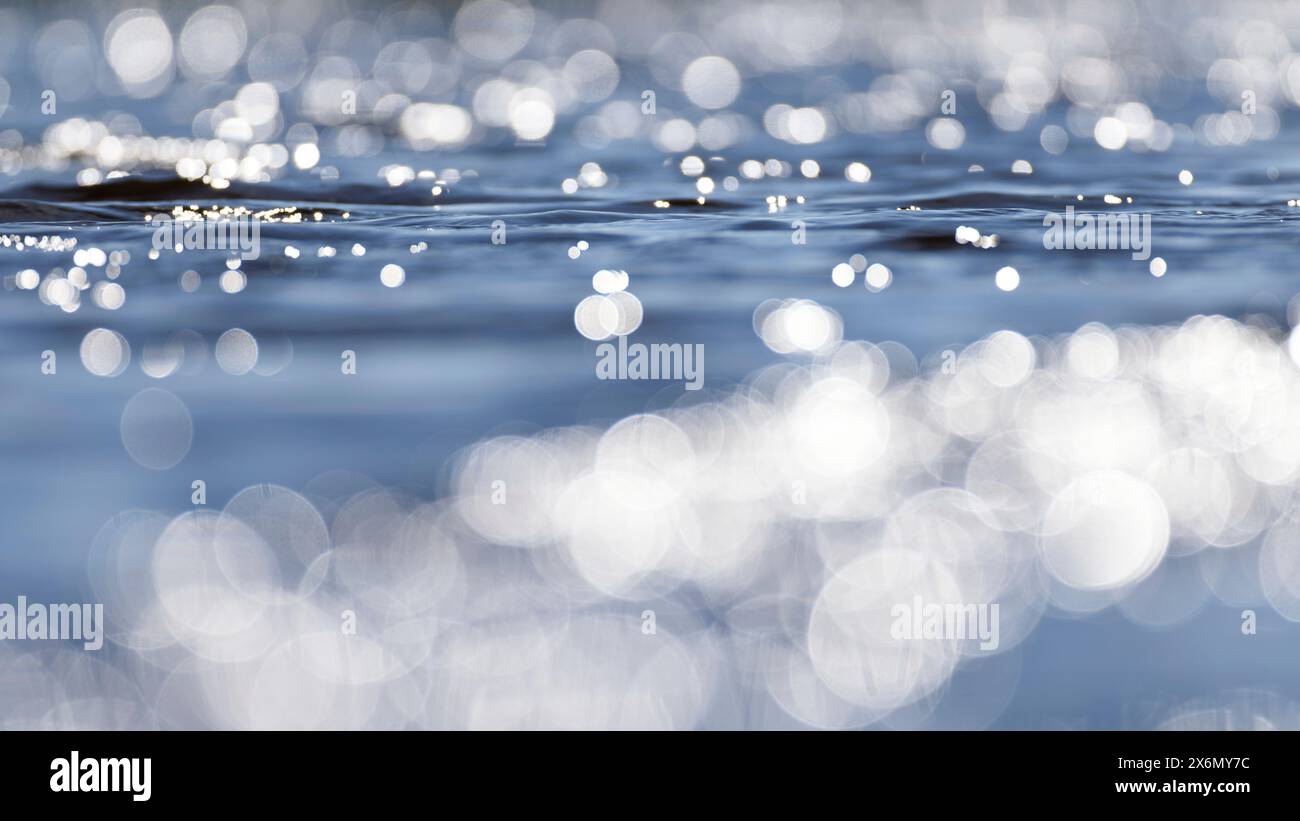 Sole, luce solare luccicante, riappiattito sull'acqua blu Foto Stock