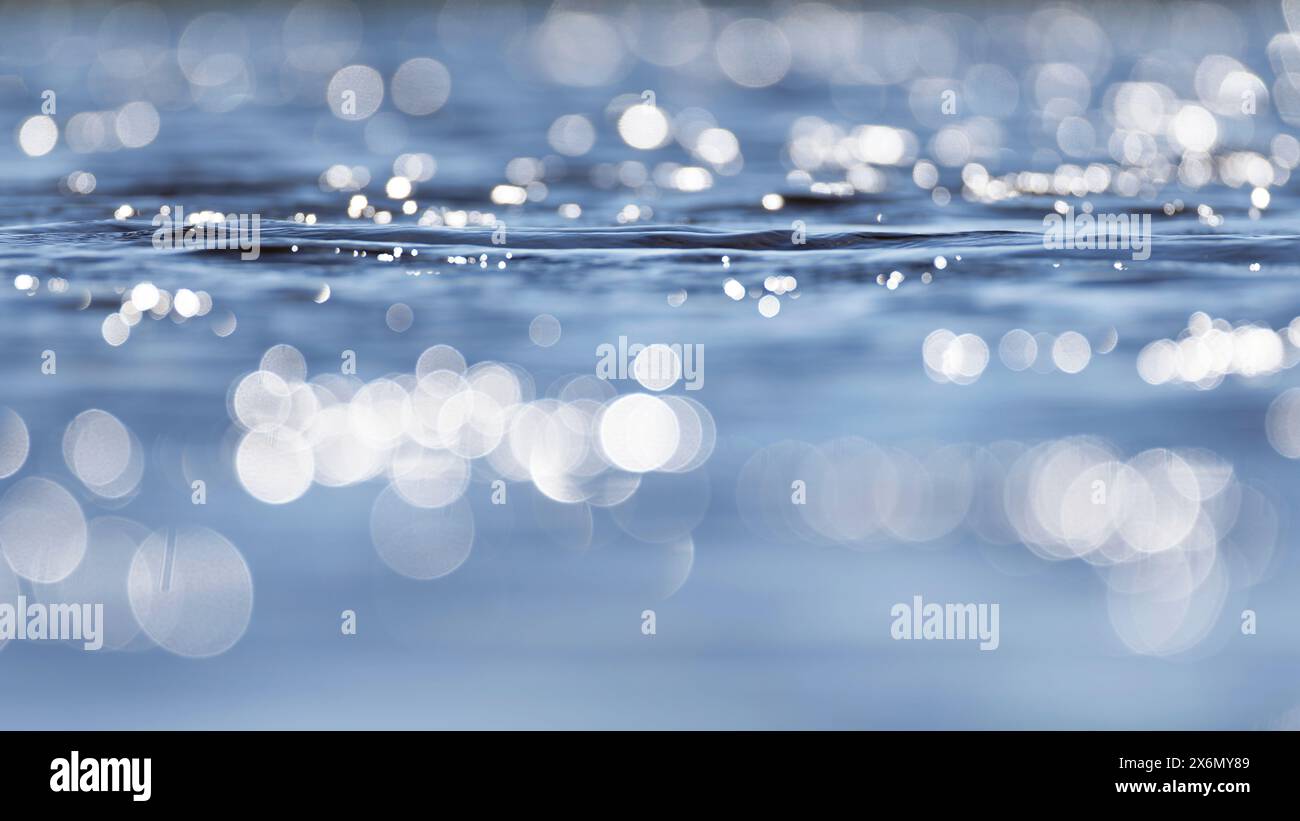 Sole, luce solare luccicante, riappiattito sull'acqua blu Foto Stock