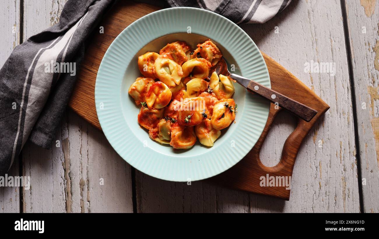 Tortelloni alla ricotta, spinaci e salsa cremosa di pomodoro. Foto Stock