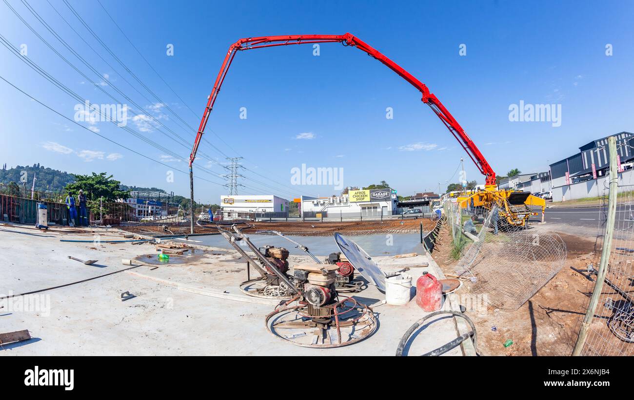 Macchina industriale da cantiere con estensione braccio idraulico per pompare calcestruzzo su pavimenti in armature in acciaio di fondamenta di edifici nuovi Foto Stock
