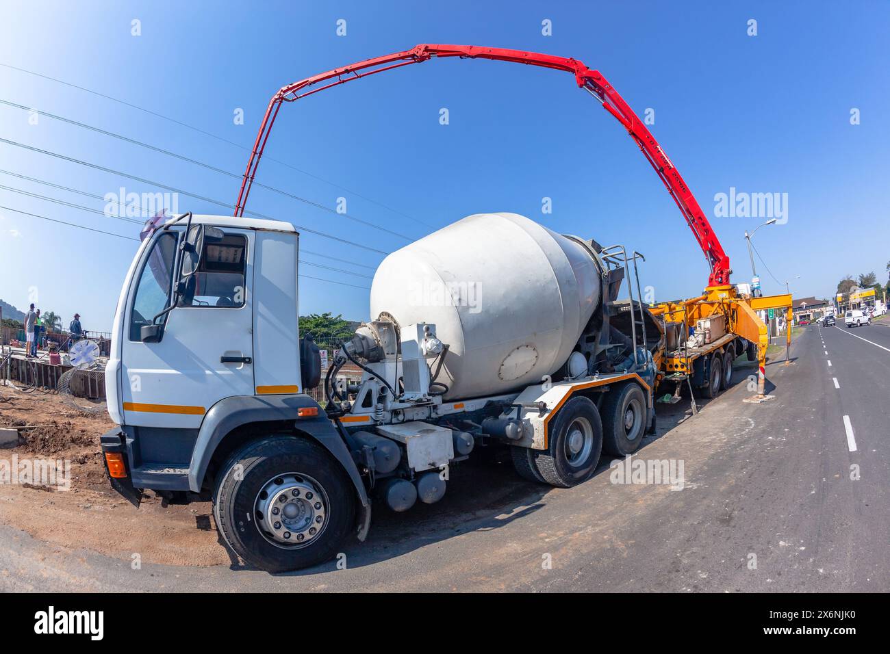 Macchina industriale da cantiere con estensione braccio idraulico per pompare calcestruzzo su pavimenti in armature in acciaio di fondamenta di edifici nuovi Foto Stock