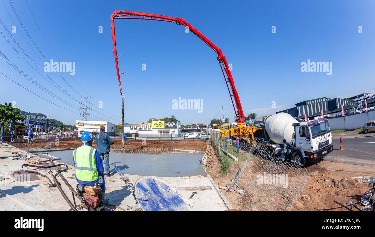 Macchina industriale da cantiere con estensione braccio idraulico per pompare calcestruzzo su pavimenti in armature in acciaio di fondamenta di edifici nuovi Foto Stock