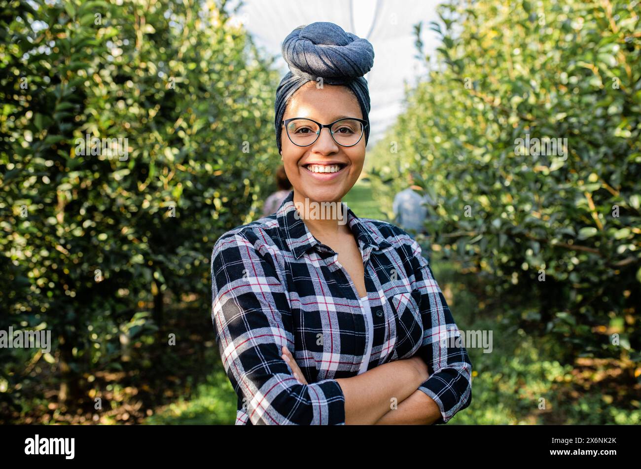 Ritratto di una giovane agricoltrice afroamericana in un frutteto. Foto Stock