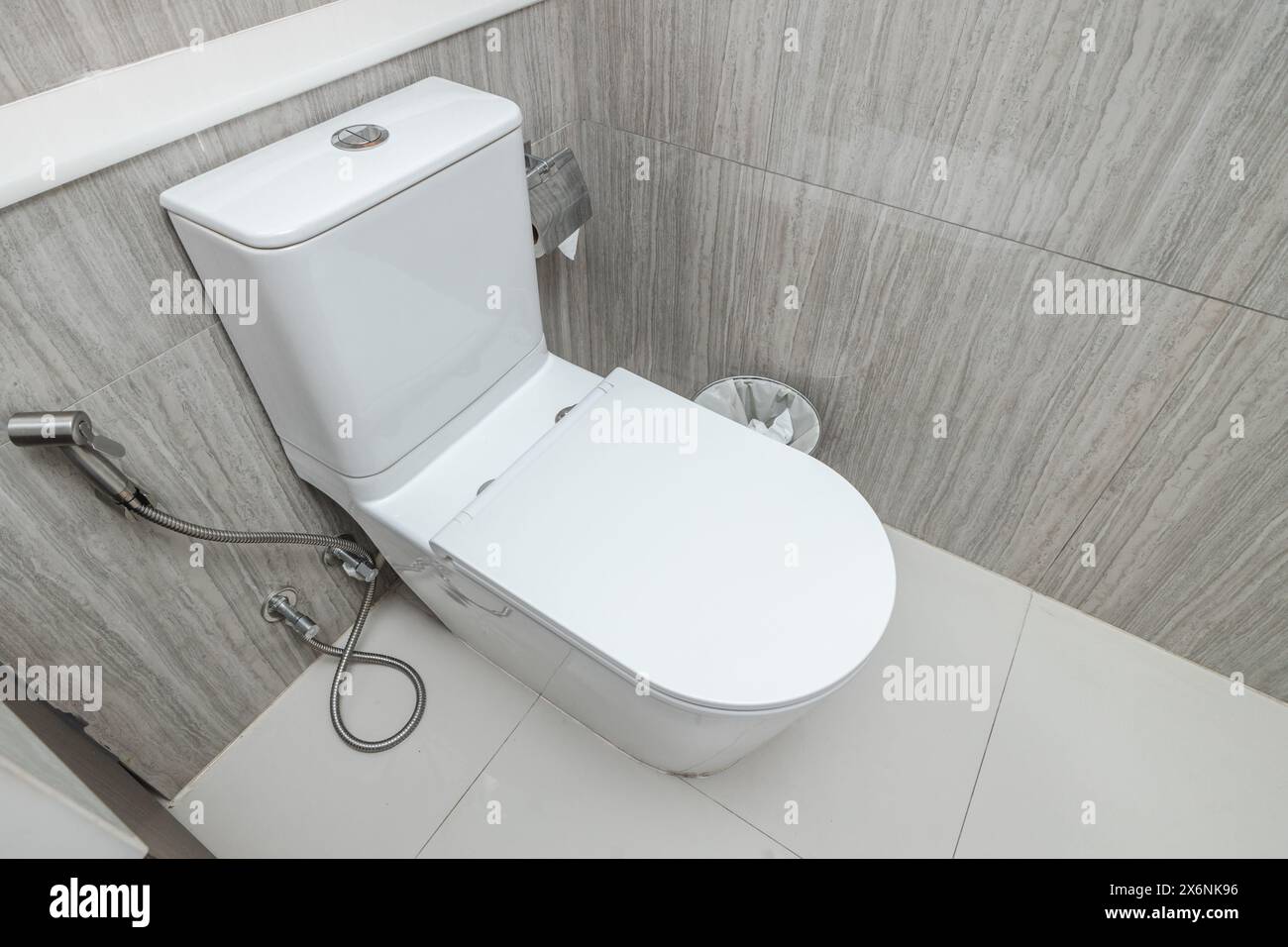 Nuova e moderna ciotola della toilette nell'arredamento interno del bagno dell'hotel Foto Stock