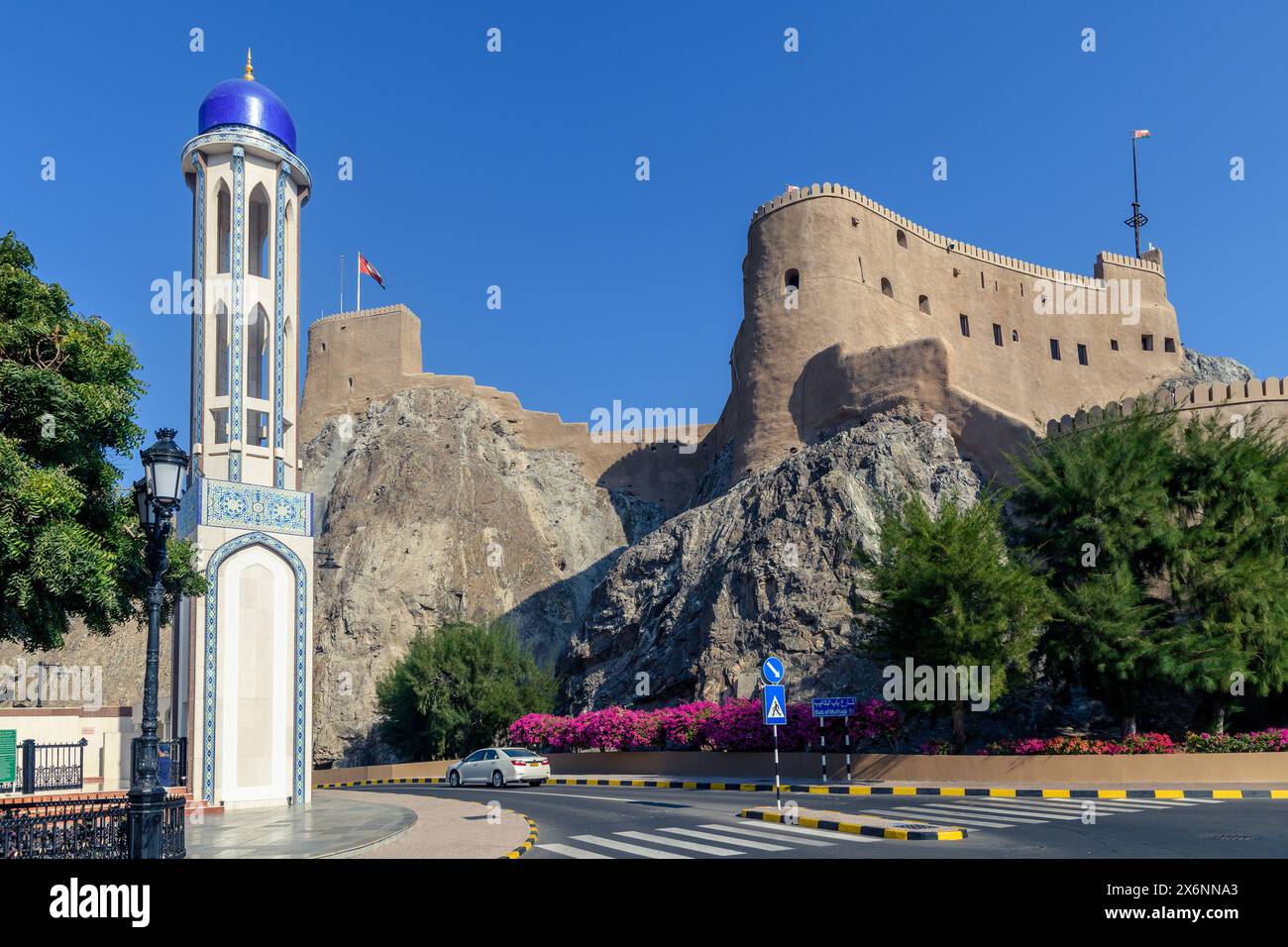 Mascate, Oman - 2 gennaio 2024: Una tranquilla mattinata vicino al forte al Mirani con l'iconica struttura che proietta una silhouette maestosa contro il blu chiaro sk Foto Stock