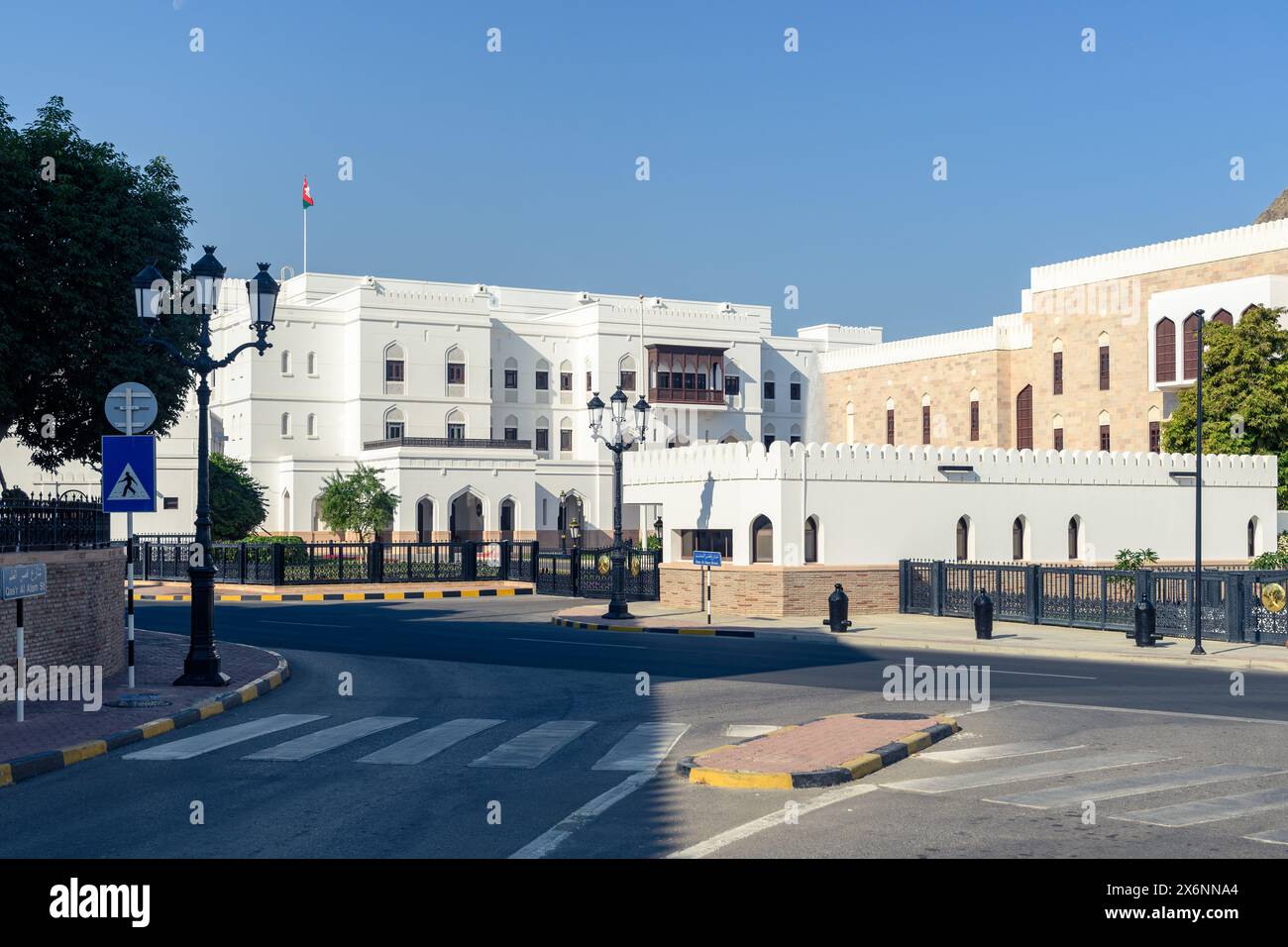 Mascate, Oman - 2 gennaio 2024: Una serena vista mattutina di una strada vuota di Mascate che mostra l'architettura incontaminata degli edifici bianchi e beige u Foto Stock