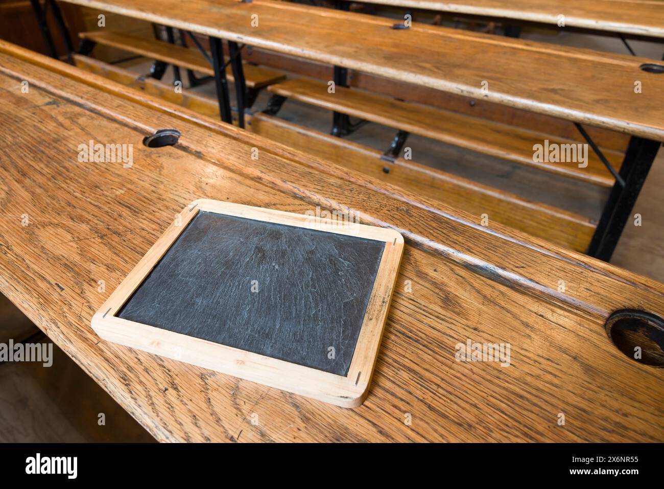 All'interno di una vecchia classe scolastica con panchine in legno tradizionali e tavolette in ardesia, Regno Unito Foto Stock