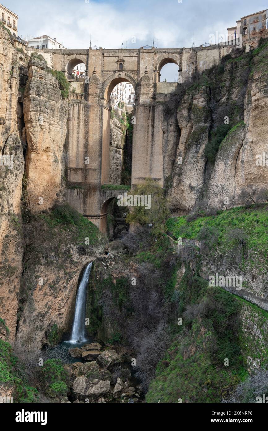 Un ponte attraversa un canyon, unendo due lati dello storico villaggio di montagna di Ronda in Andalusia, nel sud della Spagna. Foto Stock