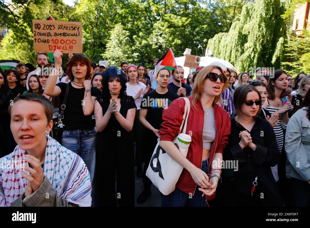 Gli studenti cantano slogan pro-Palestina e tengono bandiere e striscioni palestinesi durante la prima manifestazione in Polonia organizzata da studenti e studiosi contro l'attacco israeliano alla Striscia di Gaza di fronte al Collegium Novum, l'ufficio del preside dell'Università Jagellonica a Cracovia, Polonia, il 15 maggio 2024. Foto Stock