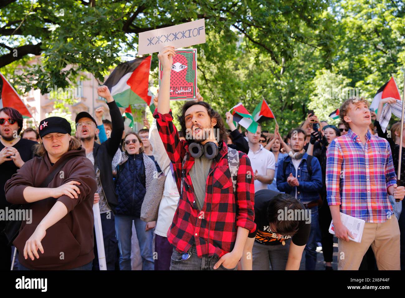 Gli studenti cantano slogan pro-Palestina e tengono bandiere e striscioni palestinesi durante la prima manifestazione in Polonia organizzata da studenti e studiosi contro l'attacco israeliano alla Striscia di Gaza di fronte al Collegium Novum, l'ufficio del preside dell'Università Jagellonica a Cracovia, Polonia, il 15 maggio 2024. Foto Stock