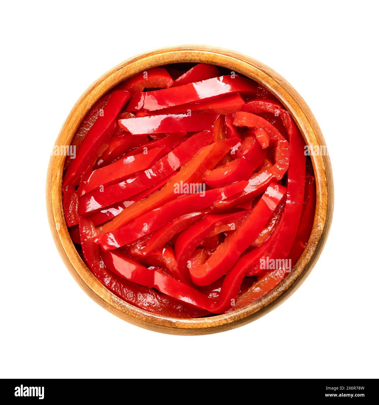 Insalata di peperoni rossi, strisce di peperoni rossi sottaceto, in un recipiente di legno. Insalata di paprika, a fette di peperoni dolci, pastorizzata e conservata in aceto. Foto Stock