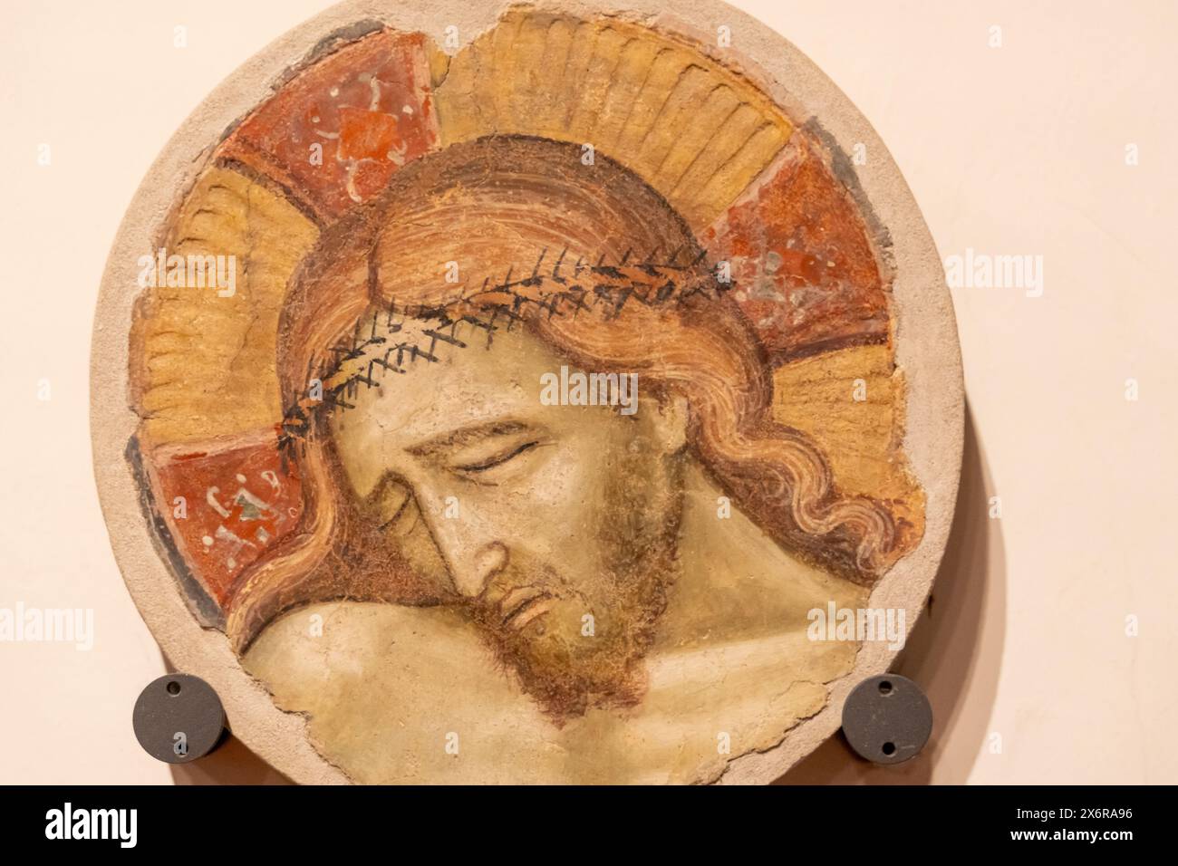 Primo piano su una placca decorativa in pietra decorata con il volto di Gesù crocifisso Foto Stock