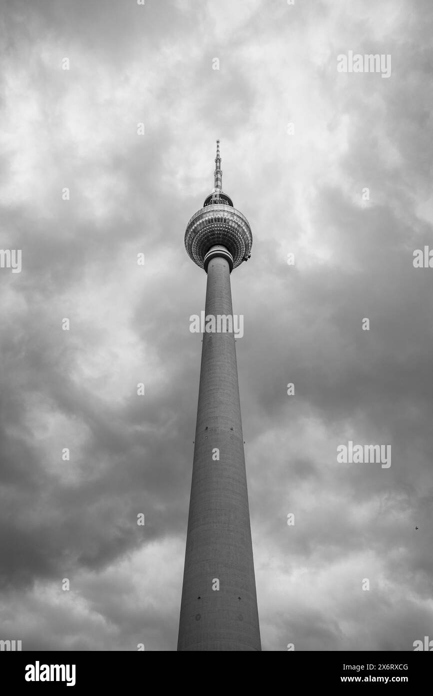La torre della televisione di Berlino è alta e si erge su un cielo spettacolare e pieno di nuvole sopra la capitale della Germania. Foto Stock