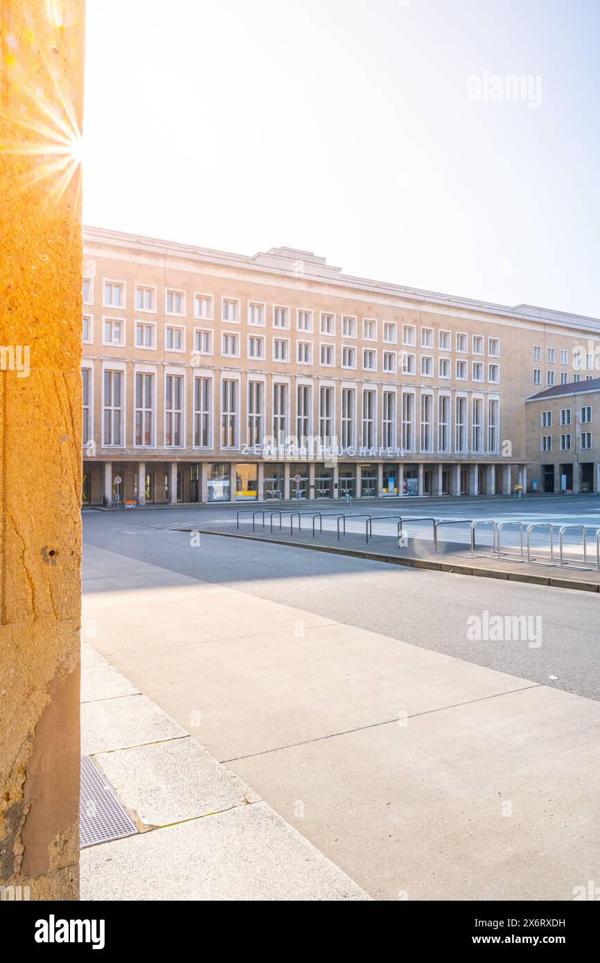 La luce del sole svetta sopra lo storico terminal dell'aeroporto di Tempelhof a Berlino, proiettando un caldo bagliore sulla sua facciata. Foto Stock