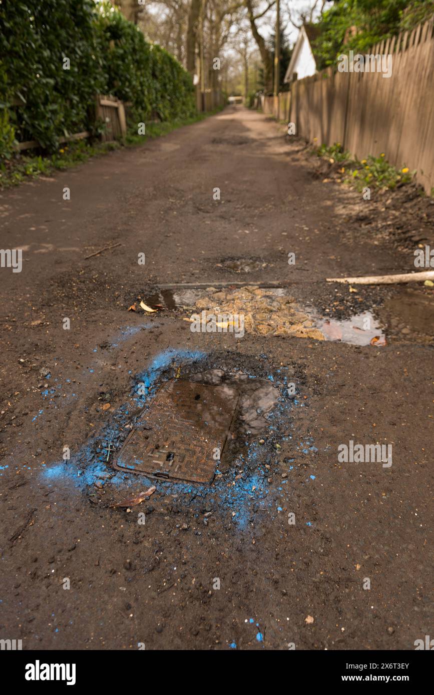 La vernice spray blu infine è stata utilizzata per identificare una perdita nell'acqua di rete solo 4 settimane dopo, distruggendo la strada non adottata Foto Stock