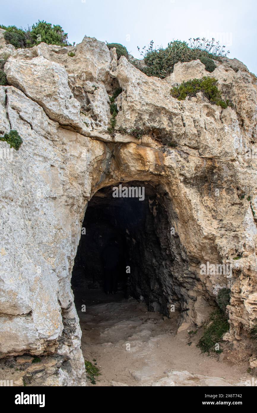 Entrada a la pequeña cueva junto al Faro del Cabo de Cavalleria, es el faro más al norte de Menorca. Minorca, España Foto Stock