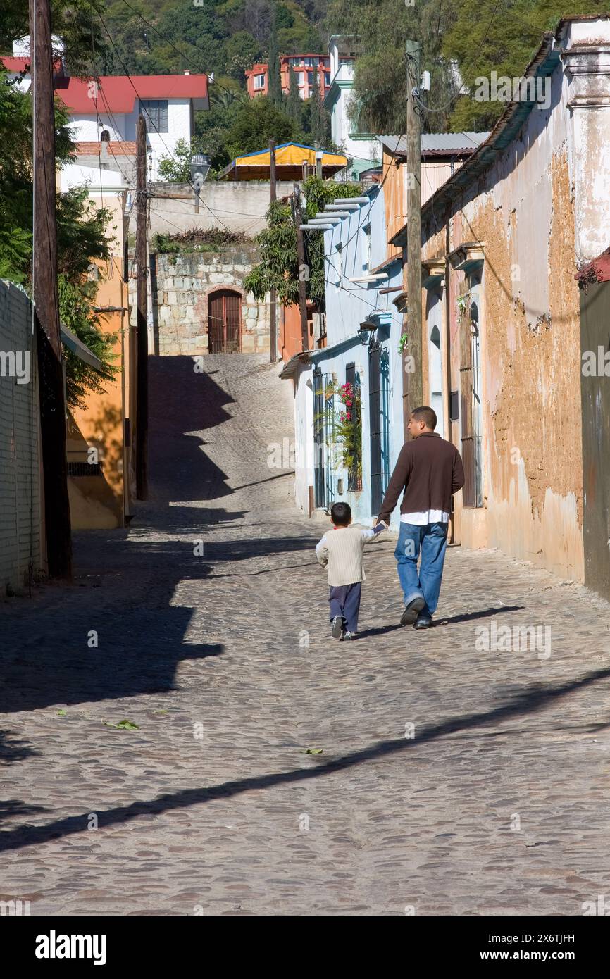 Oaxaca; Messico; Nord America. Street Scene, Calle de Morelos, zona residenziale, passeggiata tra padre e figlio. Foto Stock