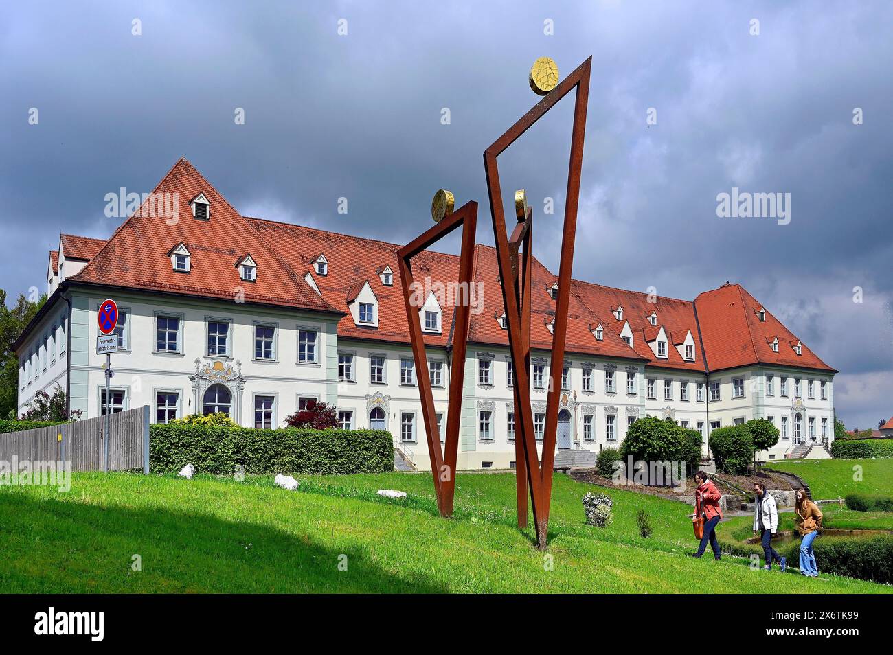 Edificio per uffici del Monastero di Ottobeuren con la scultura tre pellegrini di Erwin Roth, Ottobeuren, Allgaeu, Svevia, Baviera, Germania Foto Stock