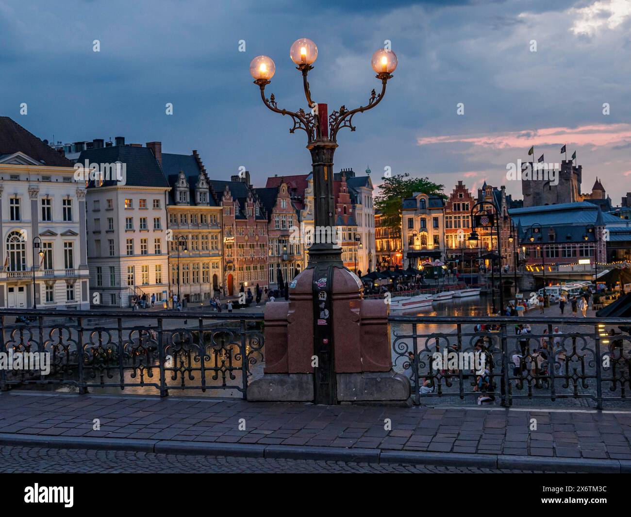 Ora blu con case storiche sul fiume con vecchie lanterne, Gand, Belgio Foto Stock
