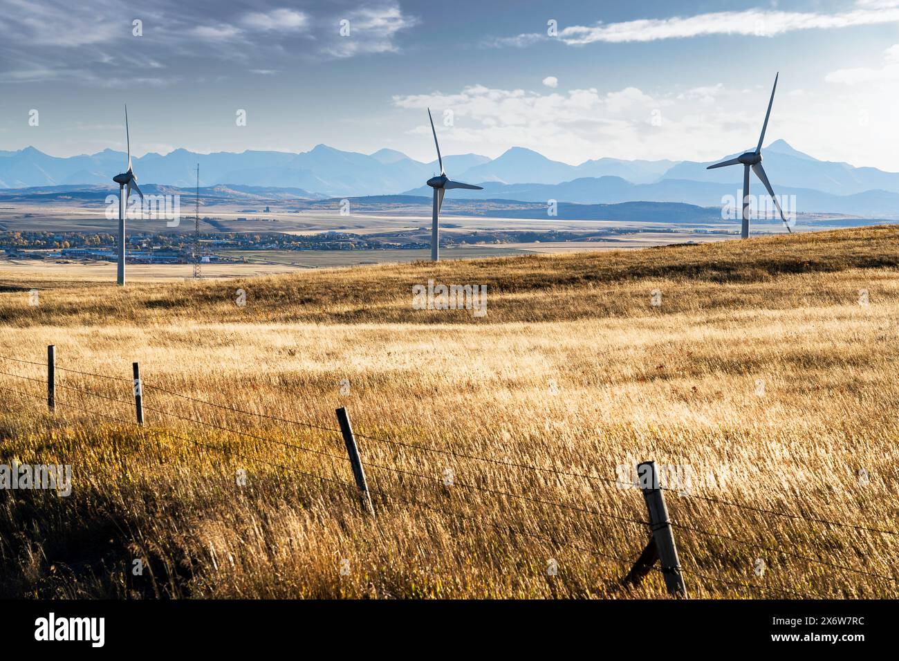 Le turbine eoliche si affacciano sulla città di Pincher Creek, Alberta, e sul Crowsnest Pass con le Montagne Rocciose sullo sfondo nel Canada occidentale. Foto Stock