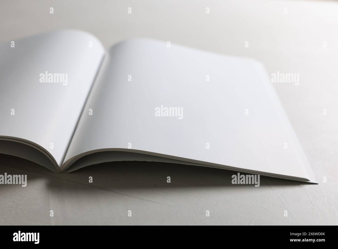 Aprire il quaderno con pagine vuote su un tavolo con texture grigia, primo piano. Mockup per il design Foto Stock