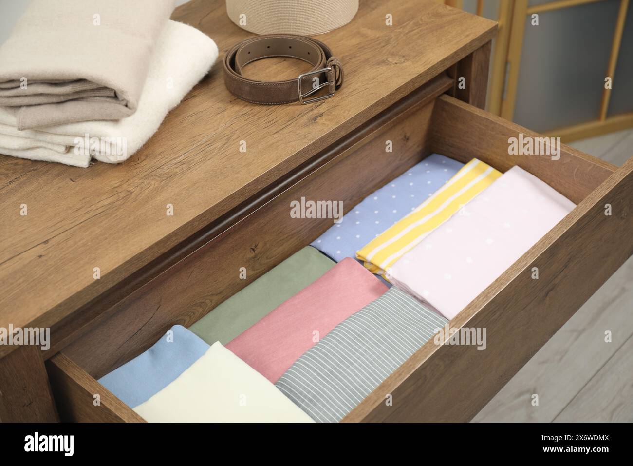 Cassettiera con diversi indumenti piegati e cintura all'interno Foto Stock