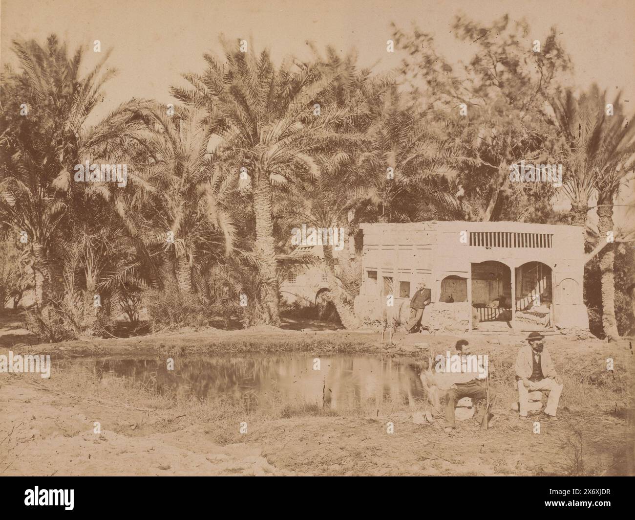 Tre uomini, seduti e in piedi accanto a uno stagno circondato da palme, fotografia, anonimo, 1851 - 1900, cartone, stampa albume, altezza, 348 mm x larghezza, 454 mm Foto Stock