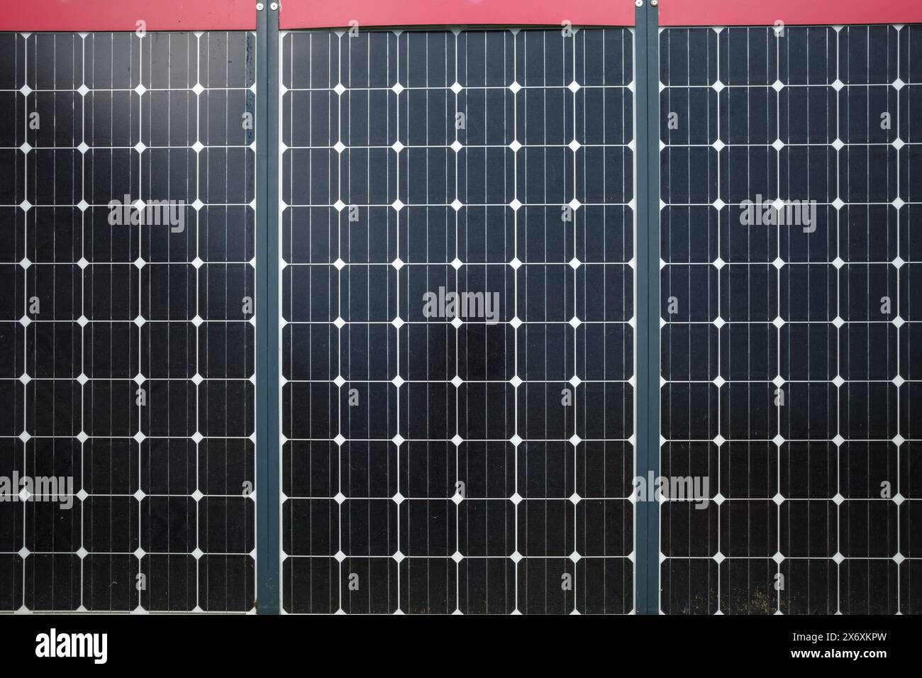 Un'immagine dettagliata di tre pannelli solari disposti in fila, che catturano l'intricato design delle celle fotovoltaiche. Foto Stock