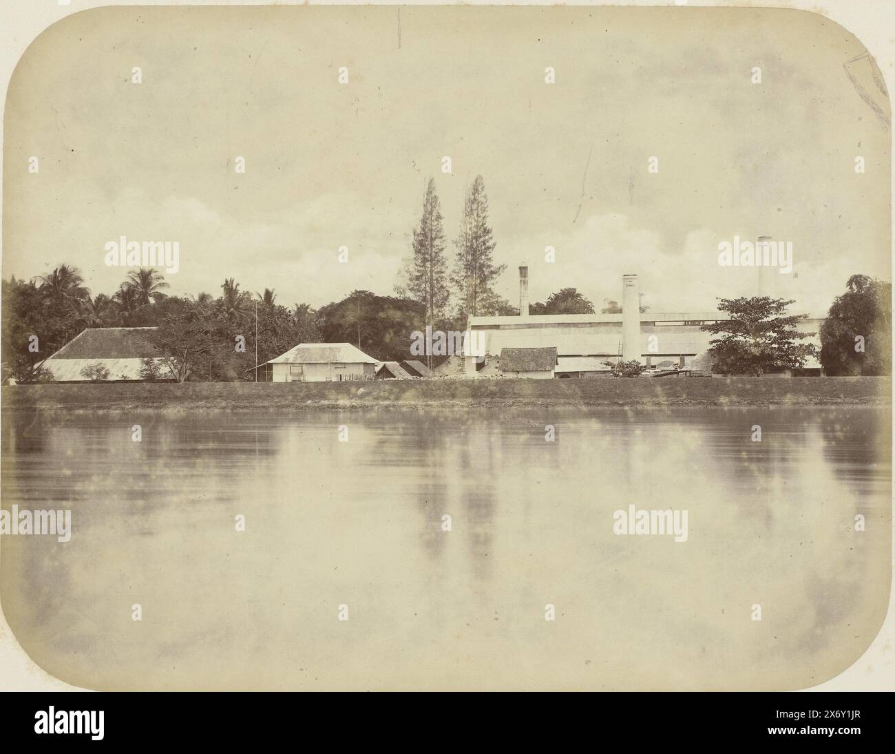 Lo zuccherificio di Ponen, lo zuccherificio di Ponen con tre camini con Ponen 1884 (!). In primo piano un fiume. Parte dell'album fotografico presentato dalla Soerabayasche Association of Sugar Manufacturers a Frederik Beyerinck, residente a Soerabaya., Fotografia, Herman Salzwedel, Soerabayasche Vereeniging van Suikerfabrikanten, Surabaya, 1876 - 1884, supporto fotografico, stampa albume, altezza, 21,8 cm x larghezza, 28,2 cm Foto Stock