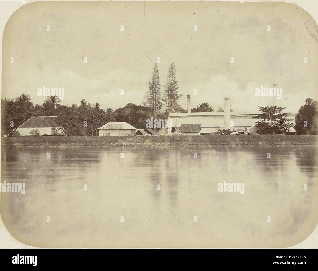 Lo zuccherificio di Ponen, lo zuccherificio di Ponen con tre camini con Ponen 1884 (!). In primo piano un fiume. Parte dell'album fotografico presentato dalla Soerabayasche Association of Sugar Manufacturers a Frederik Beyerinck, residente a Soerabaya., Fotografia, Herman Salzwedel, Soerabayasche Vereeniging van Suikerfabrikanten, Surabaya, 1876 - 1884, supporto fotografico, stampa albume, altezza, 21,8 cm x larghezza, 28,2 cm Foto Stock
