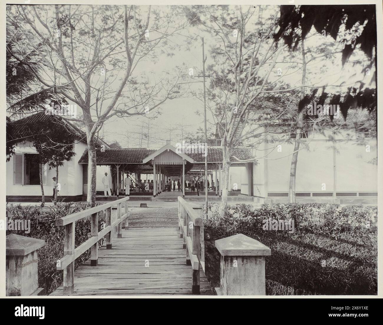 Ospedale con clinica (titolo sull'oggetto), ospedale con clinica appartenente allo zuccherificio. In primo piano un ponte di legno. Parte dell'album fotografico presentato a F.J. Wirix dai dipendenti della Djatiroto Sugar Company nel 1917., Fotografia, Atelier Kurkdjian, Jatiroto, 1917, supporto fotografico, altezza, 297 mm x larghezza, 376 mm Foto Stock