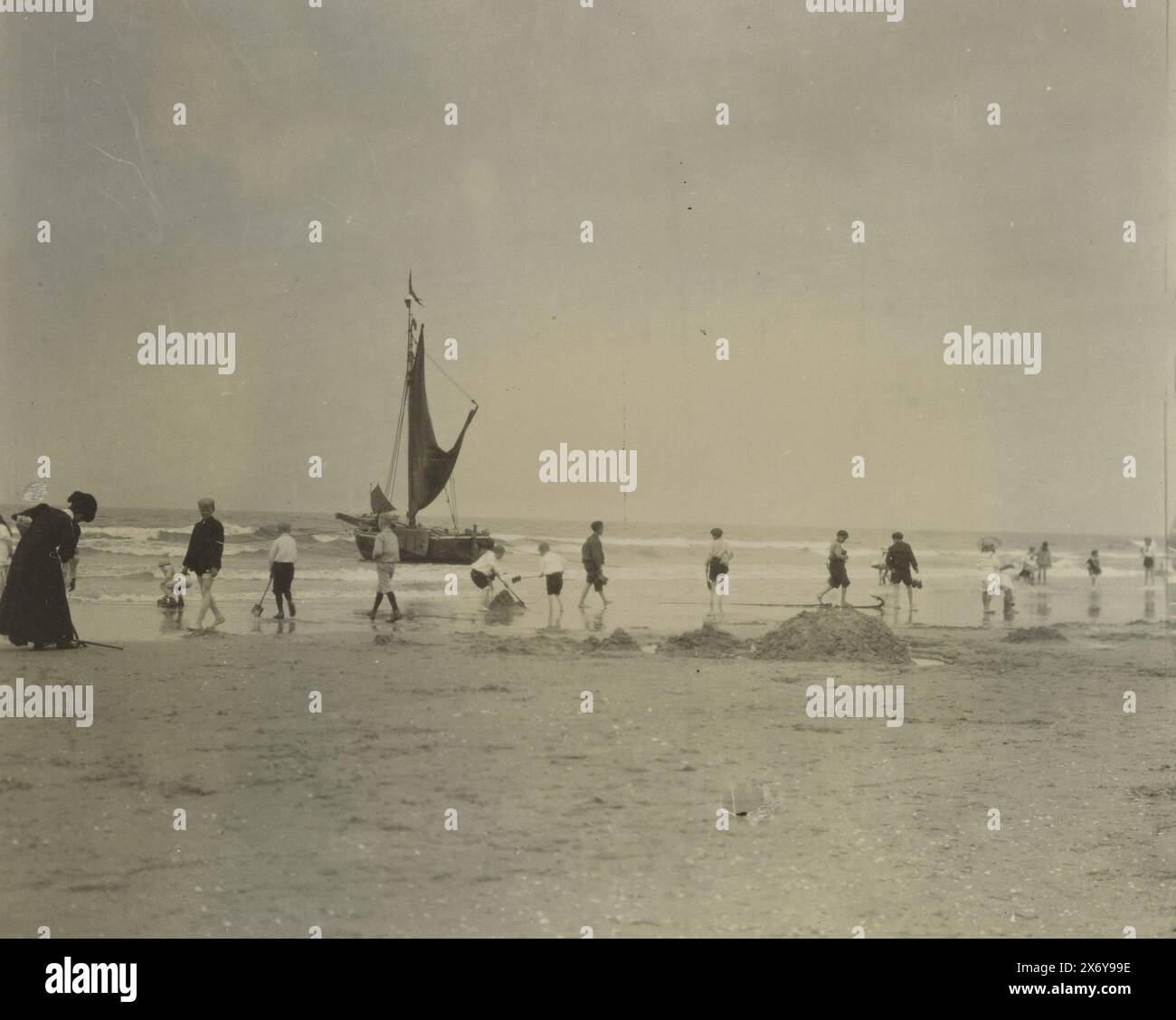 Bambini e una donna in riva al mare, con un veliero sullo sfondo (costa del Mare del Nord), Paesi Bassi o Germania, fotografia, anonima, Paesi Bassi, c. 1900, supporto fotografico, stampa in gelatina argento, altezza, 99 mm x larghezza, 126 mm Foto Stock