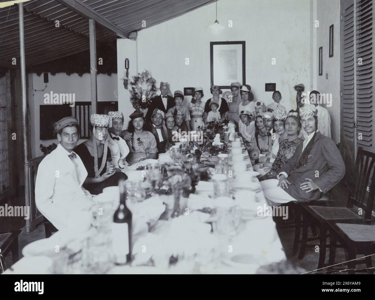 Gruppo di festa a tavola nelle Indie Orientali olandesi, parte dell'album Family con foto di una famiglia nell'ex colonia delle Indie Orientali olandesi e di una fabbrica di zucchero a Purworejo., fotografia, anonima, Indie Orientali olandesi, c. 1915 - 1920, supporto fotografico, altezza, 213 mm x larghezza, 288 mm Foto Stock