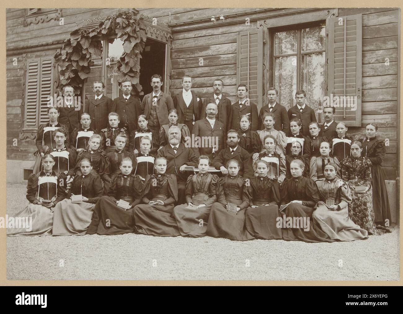 Ritratto di gruppo di una classe sconosciuta di fronte a un edificio in legno, foto della scuola con ragazze, ragazzi e insegnanti che si fingono di gruppo davanti a una casa, fotografia, anonima, 1890 - 1910, carta baryta, altezza, 155 mm x larghezza, 225 mm, altezza, 237 mm x larghezza, 313 mm Foto Stock