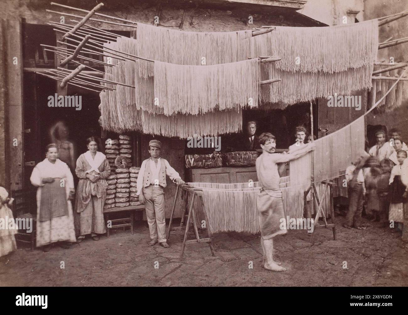 Vista sulla strada di Napoli con pastifici e scaffali per l'essiccazione degli spaghetti, Napoli (titolo sull'oggetto), fotografia, Roberto Rive, (attribuito a), Napoli, 1860 - 1889, carta, stampa albume, altezza, 192 mm x larghezza, 258 mm Foto Stock