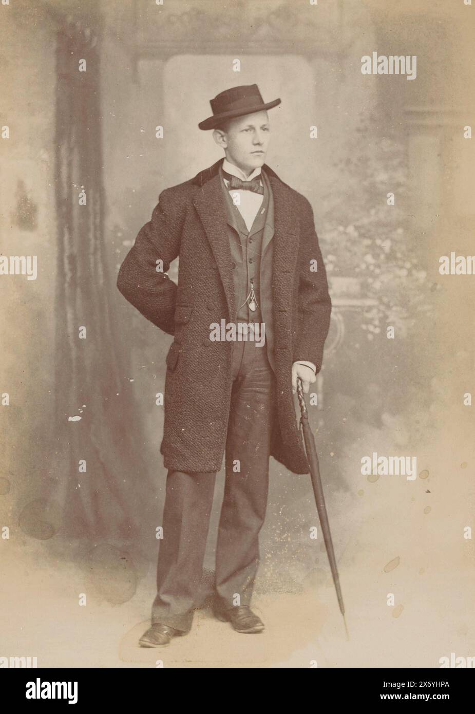 Ritratto di un uomo sconosciuto con un cappello e un ombrello, fotografia di un armadietto, Frank Hunold, (menzionato sull'oggetto), New York (città), c. 1870 - c. 1890, cartone, altezza, 140 mm x larghezza, 100 mm Foto Stock