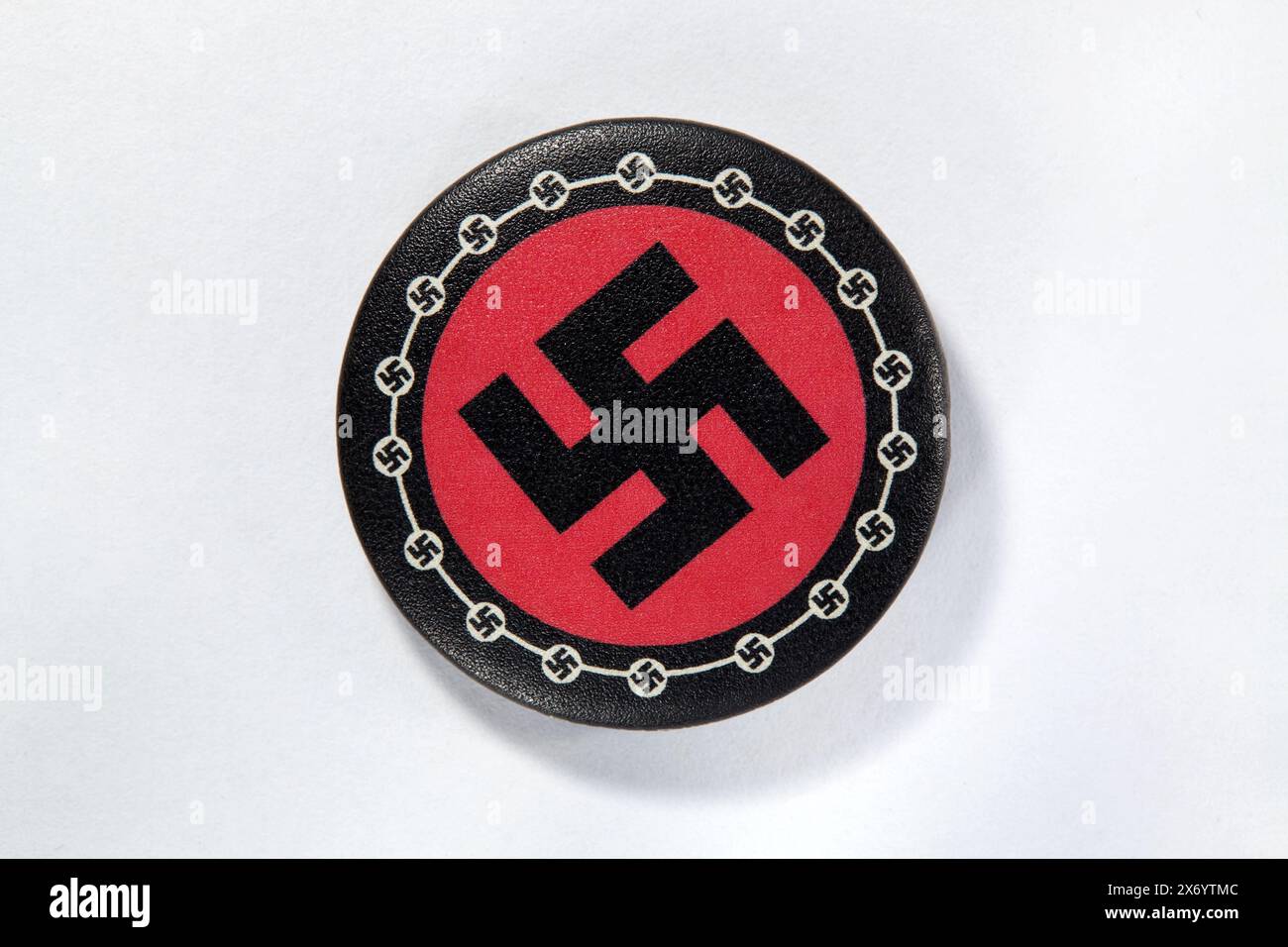Una spilla accessoria raffigurante un logo nazista con sfondo bianco Foto Stock