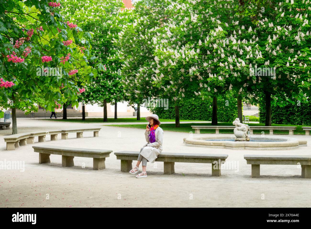 Donna seduta su una panchina di pietra nel Wallenstein Park Garden Praga Mala strana Foto Stock